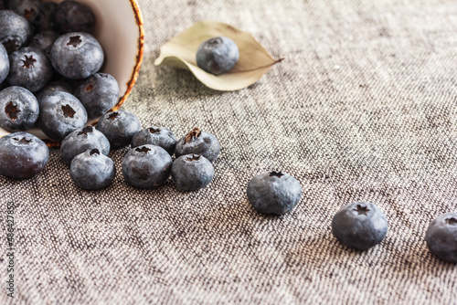 Blueberries sprinkled on a grey textured background, table. Scattered blueberries