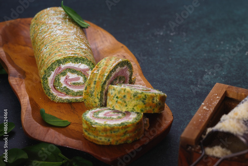 Spinach roulade filled with tomatoes, ham and ricotta for holiday dinner. Selective focus, copy space