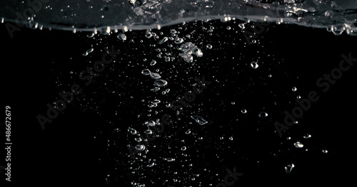 Soda water bubbles splashing and floating drop in black background represent sparkling and refreshing