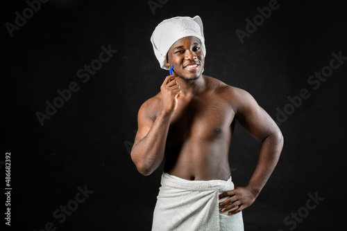 adult african man with towel shaves on black background 
