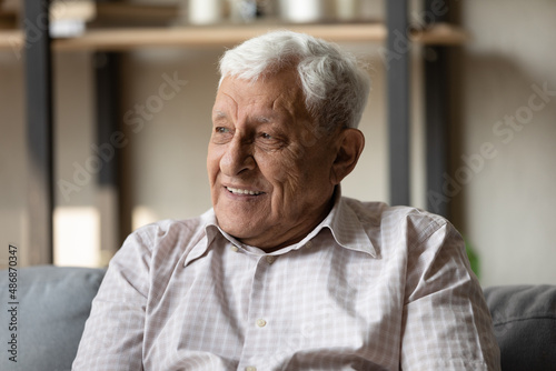 Positive pensive older 80s man looking away with good thoughts, thinking with happy smile, dreaming of optimistic future. Head shot portrait in casual. Elderly age, retirement concept