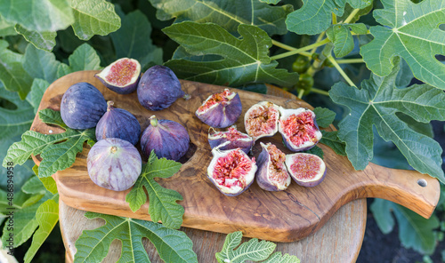Ripe fig fruits on wood board. Organic fruits on old table in the garden.