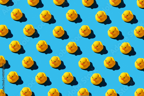 Yellow rubber duck toys pattern on seamless blue background.