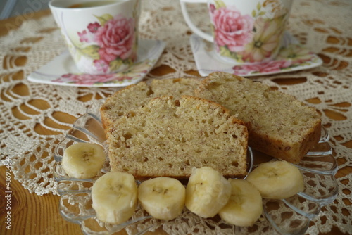 Zbliżenie chleba bananowego z filiżankami herbaty w tle