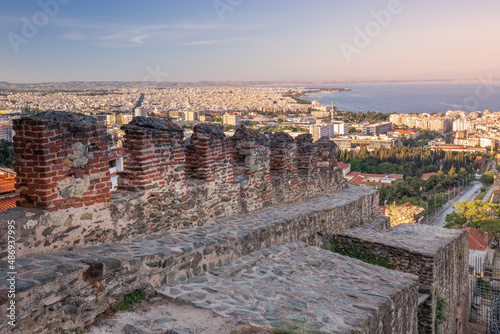 Morning cityscape with Byzantine wall ruins, downtown, bay with hazed mountains, Thessaloniki Greece