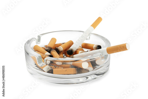 Glass ashtray with cigarette stubs isolated on white