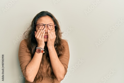 Young hispanic girl wearing casual clothes and glasses rubbing eyes for fatigue and headache, sleepy and tired expression. vision problem