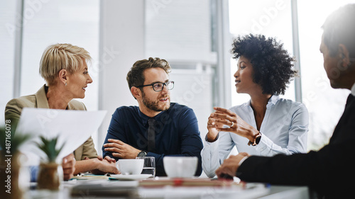 Give us difficult and well show you easy. Shot of a group of businesspeople sitting together in a meeting.