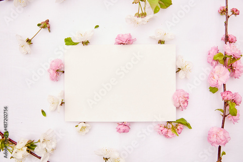Stationery card mockup with spring white and pink flowers. Romantic, wedding, birthday, invitation, mother's day mock up card concept. Copy space. Top view.
