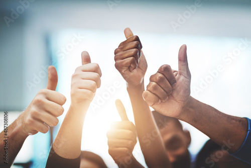 Keep up the amazing work. Cropped shot of a team of colleagues showing thumbs up at work.