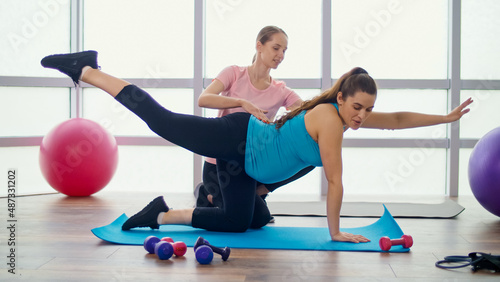 Pregnant Woman Doing Exercises for Pregnant Women with a Personal Trainer in a Fitness Class. Motherhood and Sports, Taking Care of your Body and Health.