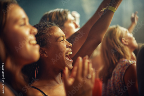 Having the time of their lives. Young girls in an audience enjoying their favourite bands performance.