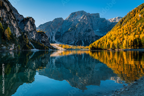 Autumn and golden reflections on Lake Braies. Park of the Dolomites.