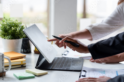 Businesswoman pointing to tablet to explain plans to work.