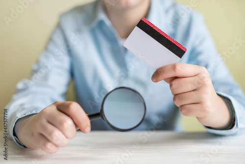 Close-up of business woman with credit card and magnifying glass