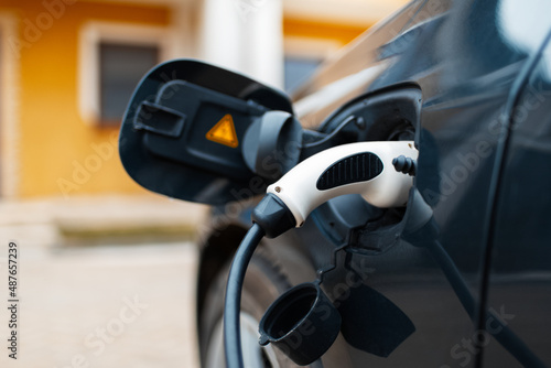 Plug-in hybrid EV car charging at charge station, home.