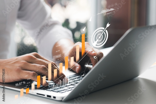 Businessman analyzing company's financial balance sheet working with digital augmented reality graphics. Businessman calculates financial data for long-term investment.