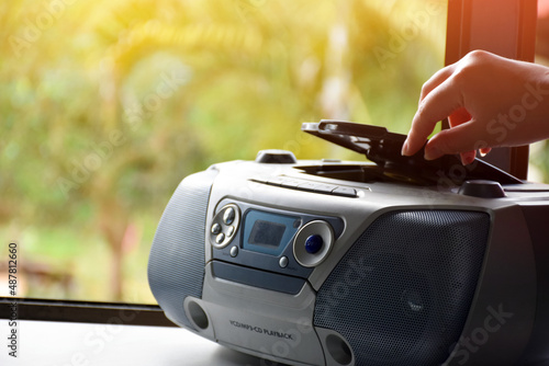 House owner is turning on the cd player which is on the balcony near the glass window to listen to the music at home, Soft and selective focus on cd player.