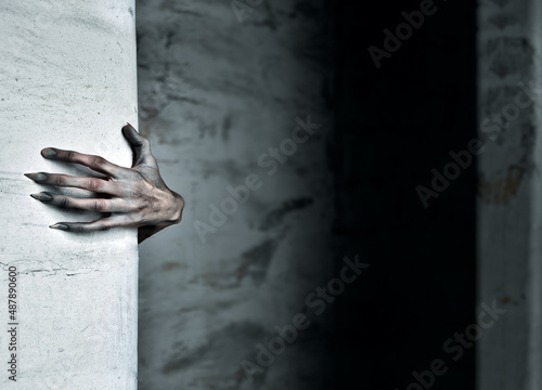 A Scary Hand Reaches out from Behind a Wall