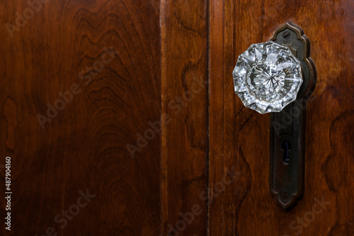 Detail of old wooden door with antique, glass, doorknob