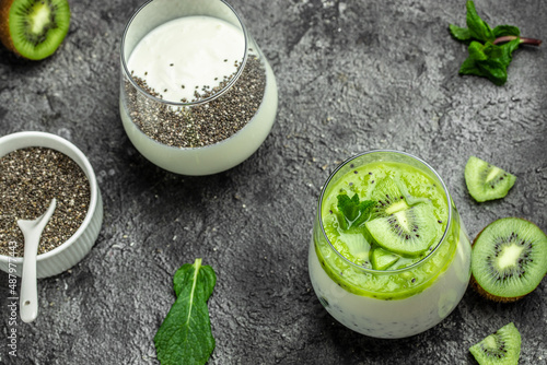 Healthy breakfast chia pudding with kiwi in glass jars on dark table. Clean eating, dieting, vegan food concept. banner, menu, recipe, place for text