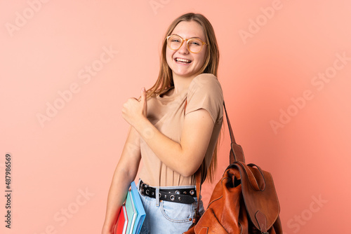 Teenager Ukrainian student girl isolated on pink background celebrating a victory