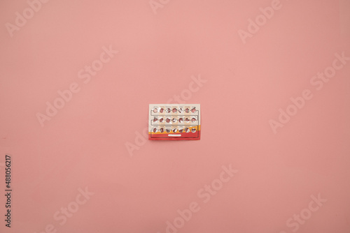 Female oral contraceptive pills blister on pink background. Women contraceptive hormonal birth control pills. Planning pregnancy concept. Copy space, flat lay.
