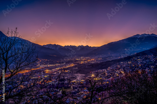 sunset over Aosta city with snow-capped mountains in the background and colorful sky