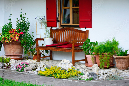 drewniana, brązowa ławka w ogrodzie pod oknem, sitting area in the garden, wooden garden bench 