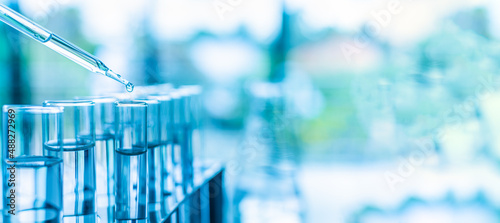 Concept of chemical, scientific experiment, monkeypox virus. Closeup, copy space on right. Chemistry experiments in science labs. Drop chemical matter into test tube place on desk. Blurred background