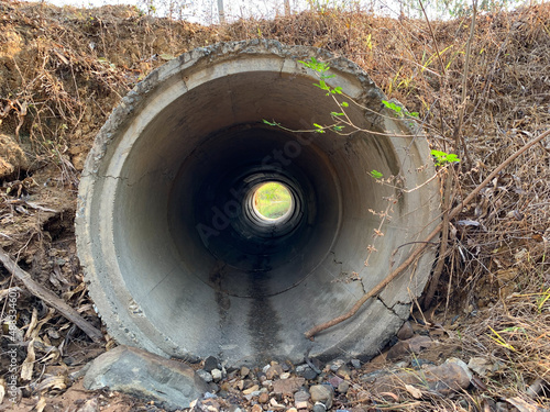 A concrete culvert that is under a road in the summer of the countryside, Image from mobile phone