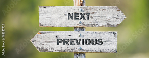 opposite signs on wooden signpost with the text quote next previous engraved. Web banner format.