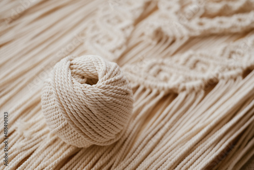 White natural cotton macrame cord in a roll on a handmade wall hanging.