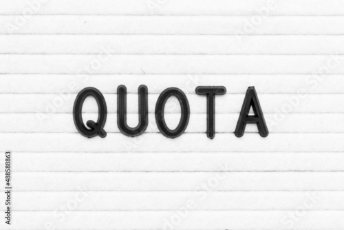 Black color letter in word quota on white felt board background