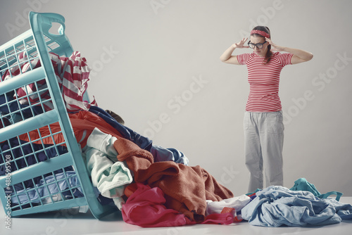 Disappointed angry woman looking at dirty clothes