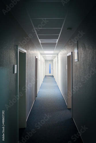 long narrow hallway leads to a white door