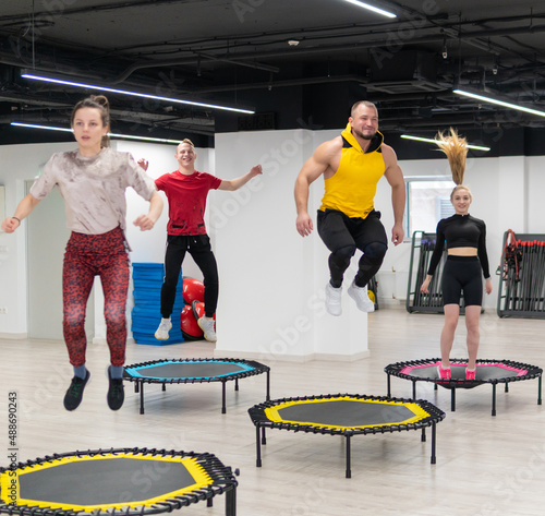 Women's and men's group on a sports trampoline, fitness training, healthy life - a concept trampoline group batut workout health, for female team for fitness from sport shaping, smiling sportswear