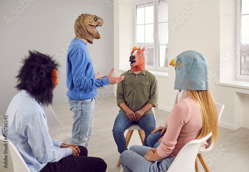 People wearing funny masks having a conversation during a group therapy session. Different male and female patients with animal faces talking, sharing their problems, and looking for solutions