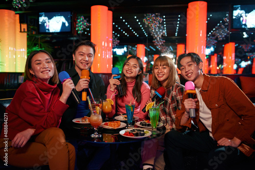Karaoke together with friends and enjoying time in karaoke club,