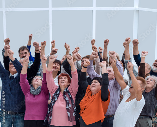 a group of elderly people raised their hands up