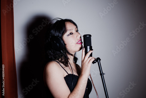 Adolescente cantando frente a un micro de estudio
