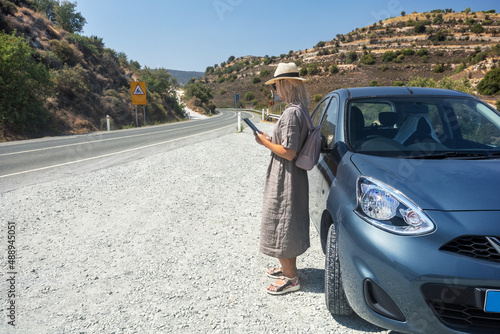 Mature woman on vacation travel by car in mountains. Summer holiday and car travel concept.
