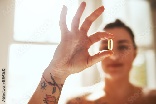 Medicinal help for your health. Shot of a woman taking a pill during her morning routine at home.