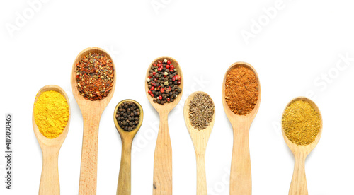 Wooden spoons with different spices isolated on white background, closeup