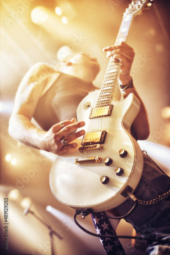 Low angle view of a guitarist on stage at a gig. This concert was created for the sole purpose of this photo shoot, featuring 300 models and 3 live bands. All people in this shoot are model released.