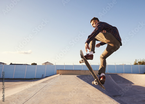 A rad day at the skate park. A young man doing tricks on his skateboard at the skate park.