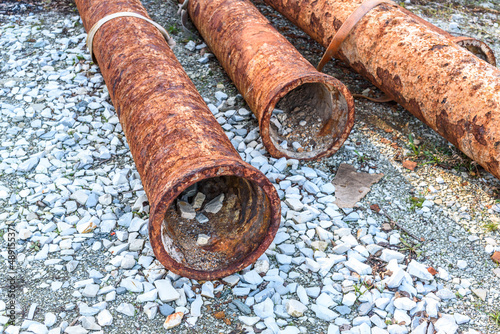 Pile of old rusty round metal industrial pipe