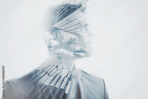 Reaching for the sky. Composite image of a well-dressed man superimposed with images skyscapers.