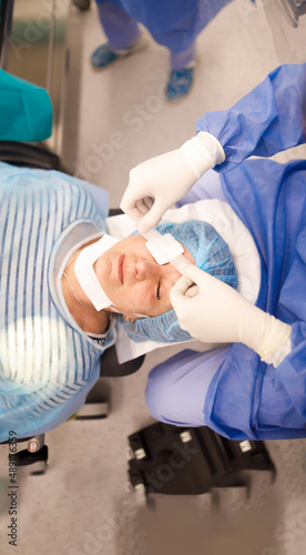 Doctor putting an eye patch on his patient after a successful cataract operation