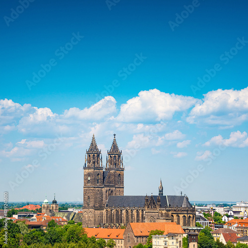 Cover page with Magdeburg historical downtown, Elbe river, city park and the ancient medieval cathedral in Spring colors at blue cloudy sky and sunny day, Magdeburg, Germany.